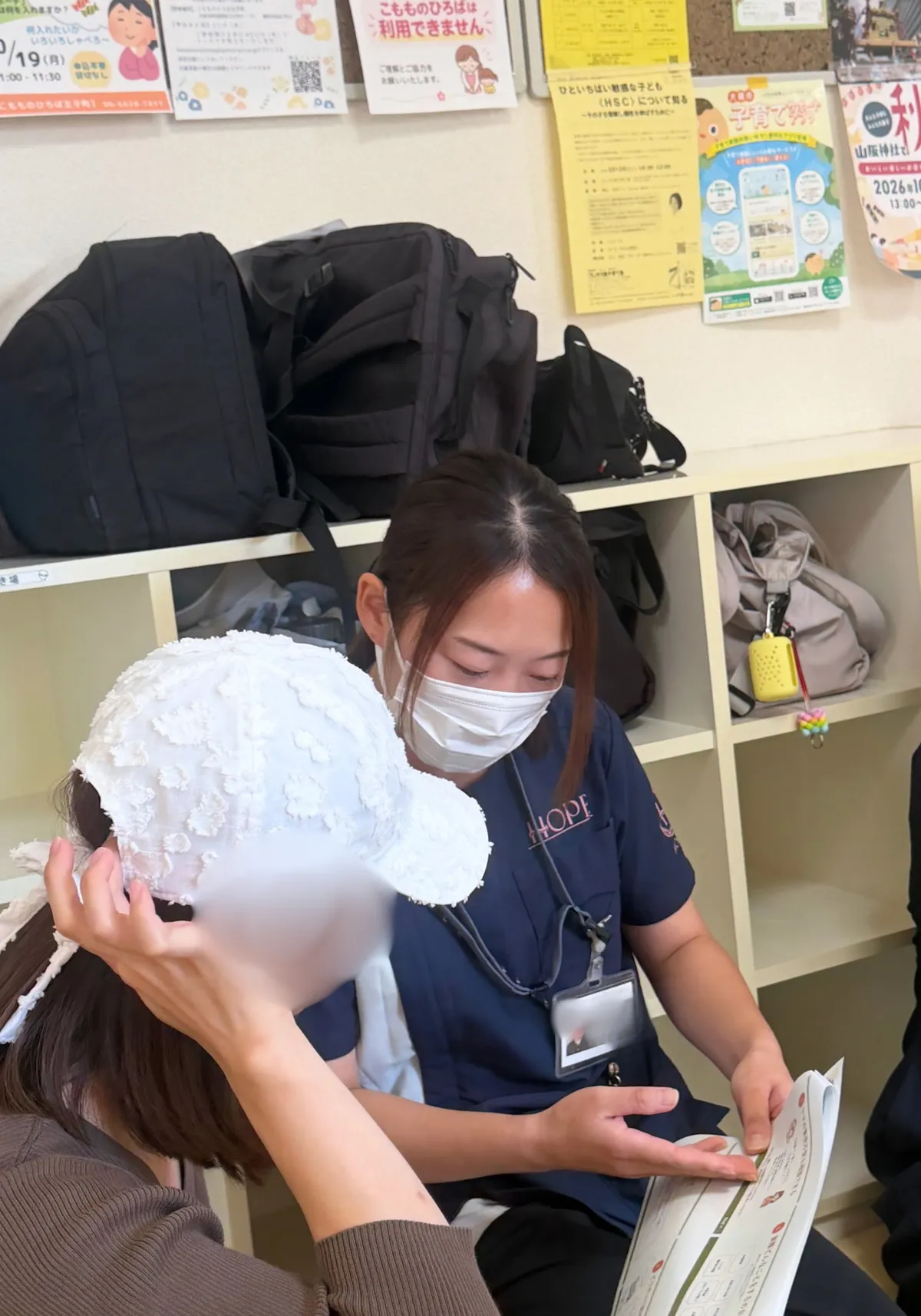 参加された方に資料を見せながら説明する、ホープの看護師