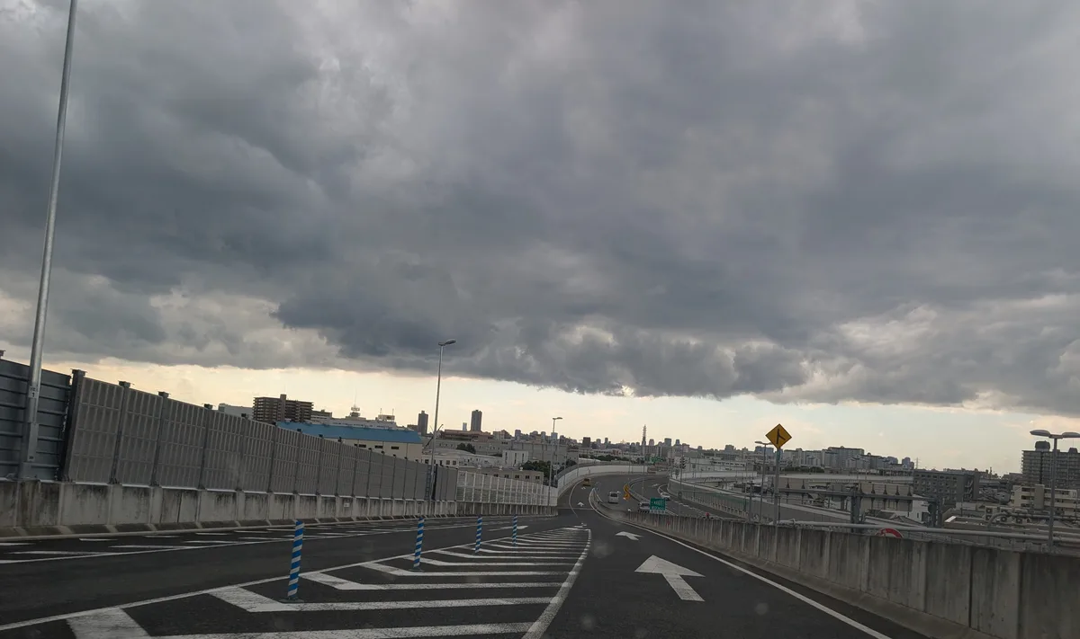 厚い雲の切れ間から明るい空がのぞく、大阪の街並み