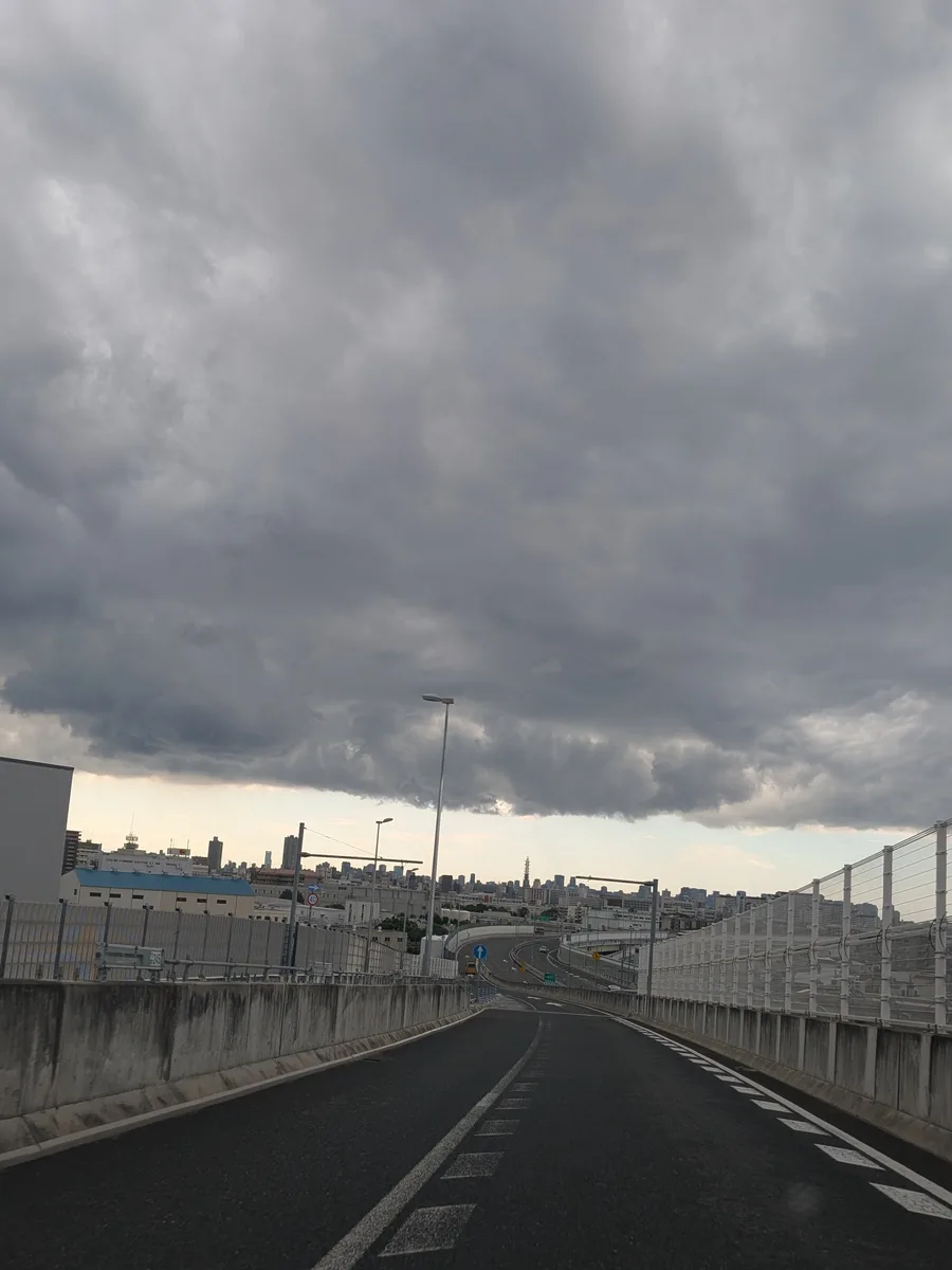厚い雲の切れ間から明るい空がのぞく、大阪の街並み
